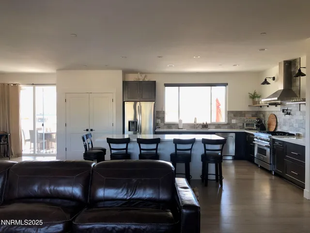 a living room with furniture a large window and kitchen view