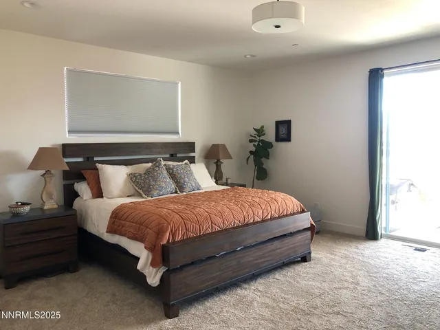 a spacious bedroom with a bed and window