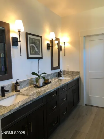 a bathroom with double sink and a mirror