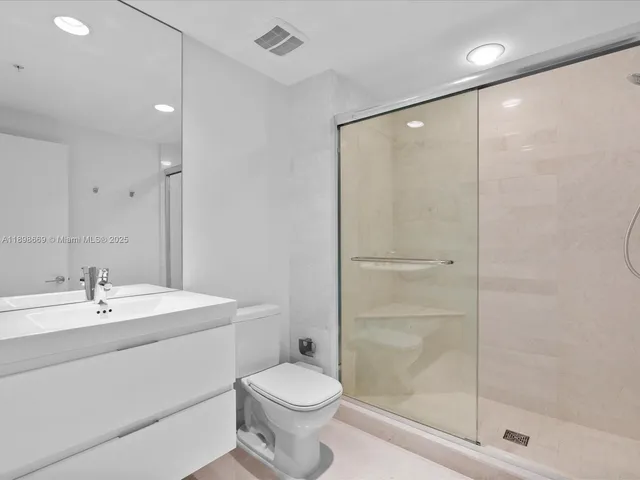 a bedroom with a bed and a flat tv screen next to a window