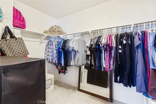 a view of walk in closet with clothes