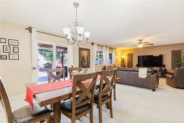 a view of a dining room with furniture a chandelier and a flat screen tv