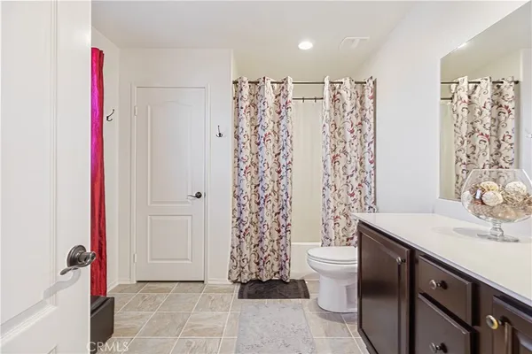 a bathroom with a sink a toilet and shower curtain