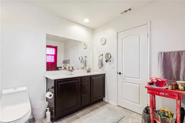 a bathroom with a sink vanity mirror and toilet