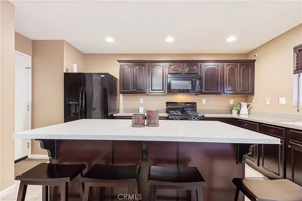 a kitchen with stainless steel appliances a dining table and chairs