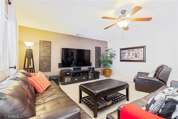 a living room with furniture a flat screen tv and a large window