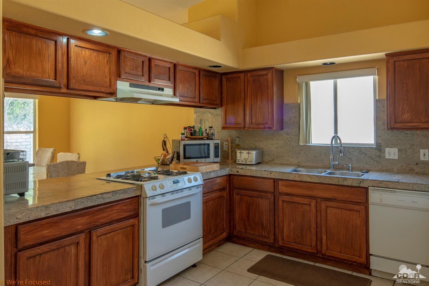 67235 Ovante Road Cathedral City, CA 92234 - Photo 6 of 16 a kitchen with a sink stove and cabinets