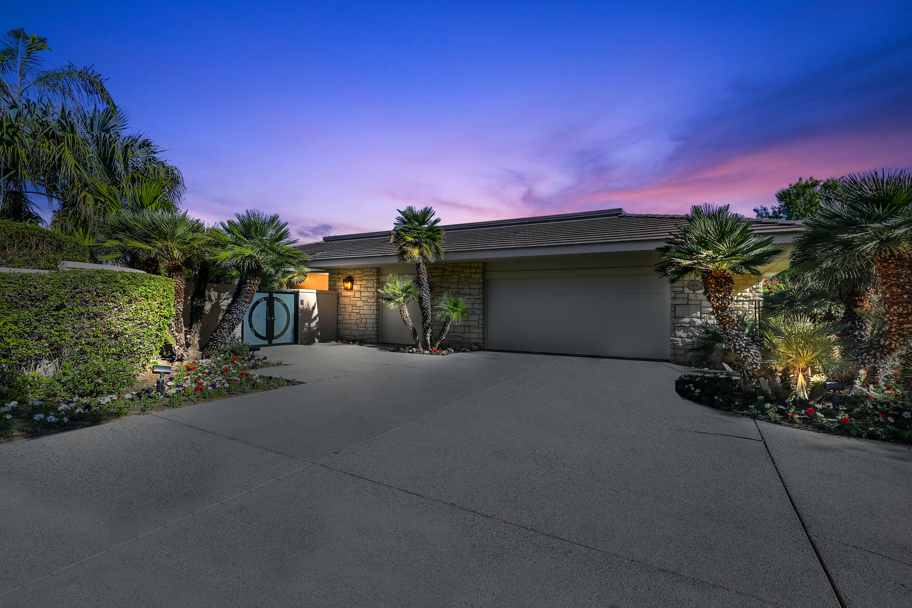 44 Fincher Way Rancho Mirage, CA 92270 - Photo 3 of 56 a front view of a house with a yard and a garage