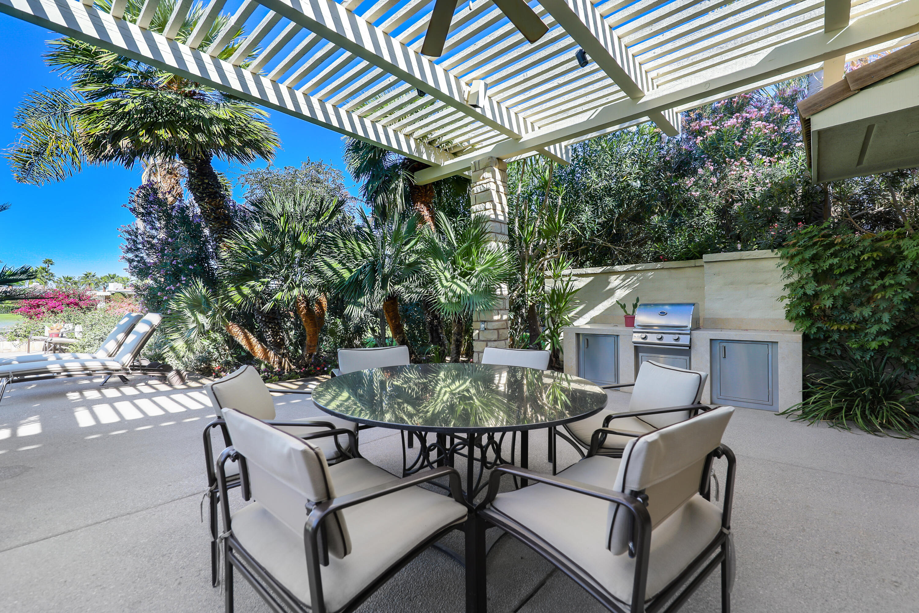 44 Fincher Way Rancho Mirage, CA 92270 - Photo 39 of 56 a backyard of a house with table and chairs and potted plants