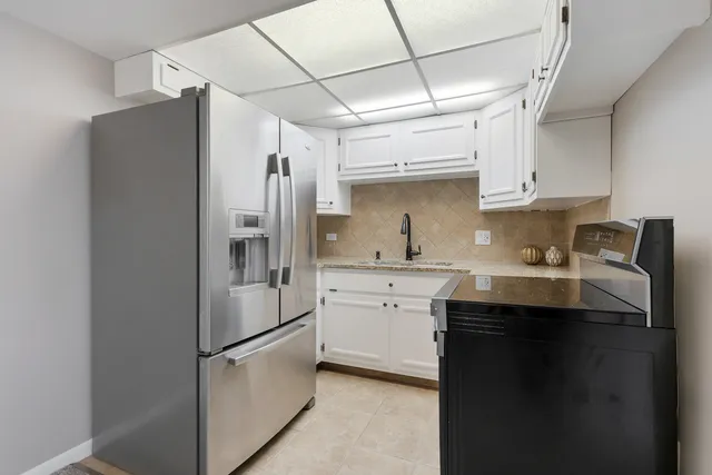 a kitchen with stainless steel appliances granite countertop a refrigerator a sink and dishwasher