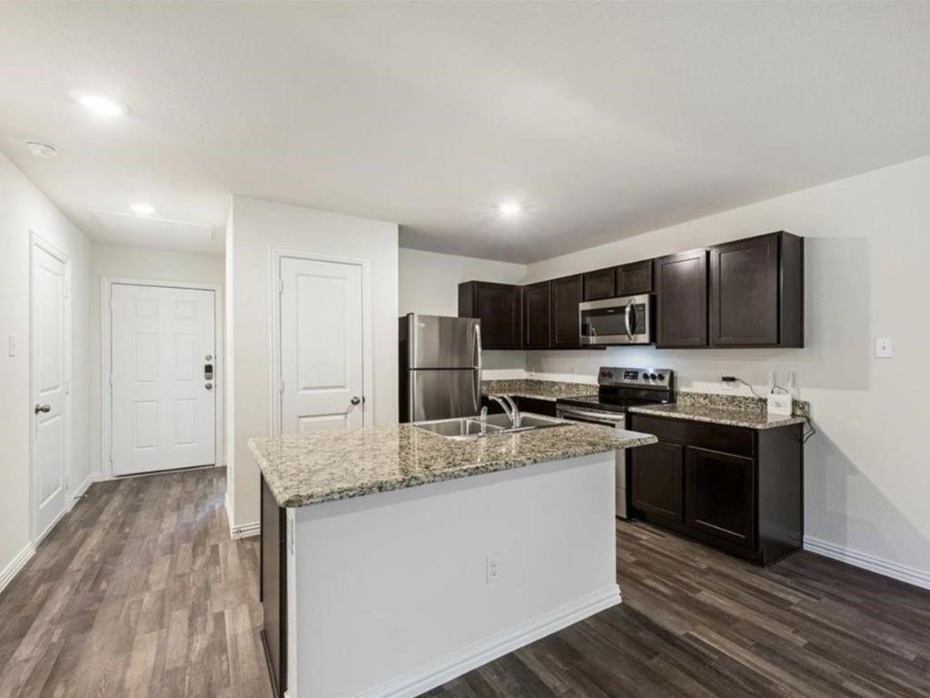 1007 Dawson Street Waco, TX 76704 - Photo 2 of 20 a kitchen with stainless steel appliances granite countertop a stove top oven a sink dishwasher a refrigerator and cabinets with wooden floor