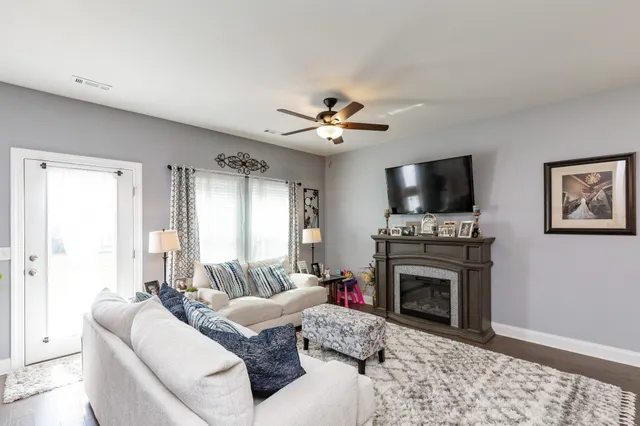 a living room with furniture a fireplace and a flat screen tv