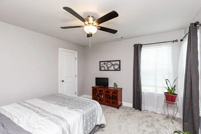 a bedroom with a bed dresser and a window