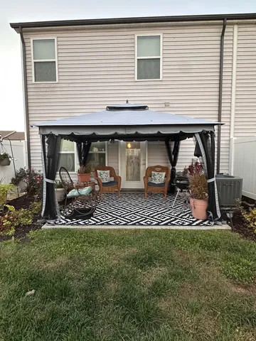 a backyard of a house with table and chairs