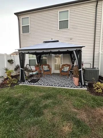 a backyard of a house with table and chairs