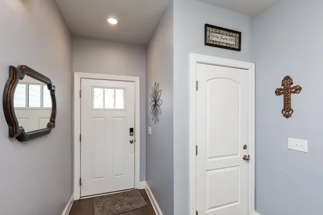 a view of a hallway with front door wooden floor and windows