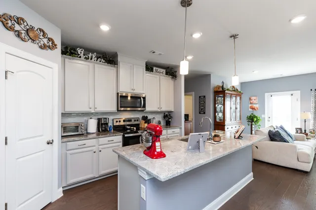 a kitchen with kitchen island white appliances cabinets and a counter top space