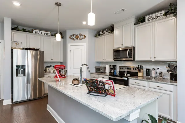 a kitchen with refrigerator a stove a sink and a microwave