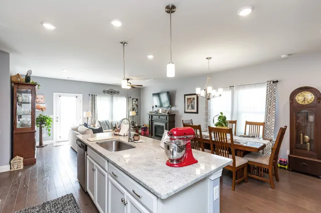 a view of a dining room and livingroom with furniture wooden floor a chandelier