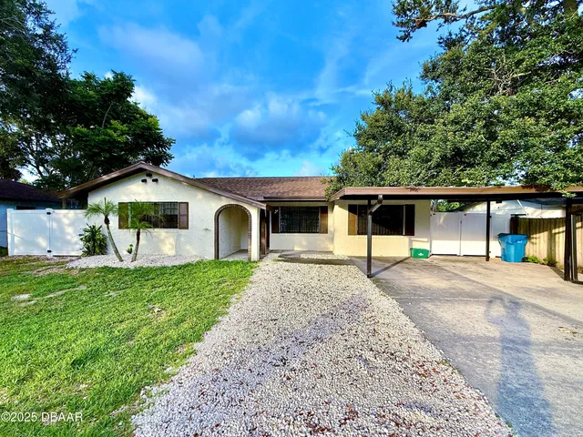 a front view of a house with a garden and trees
