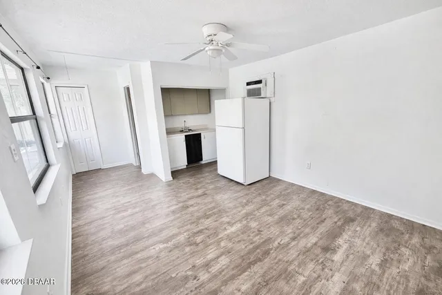a view of empty room with a fireplace and window