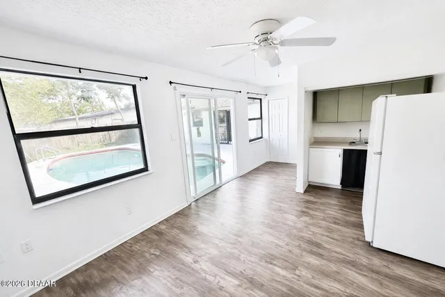 a view of a kitchen with wooden floor and a hallway