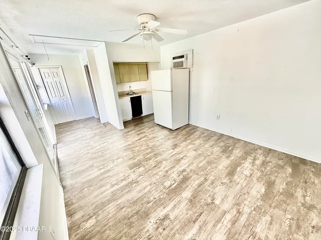 a view of empty room with wooden floor and window