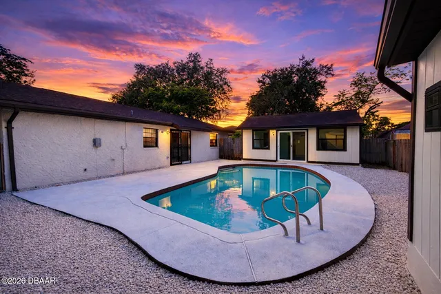a view of a house with swimming pool and a yard