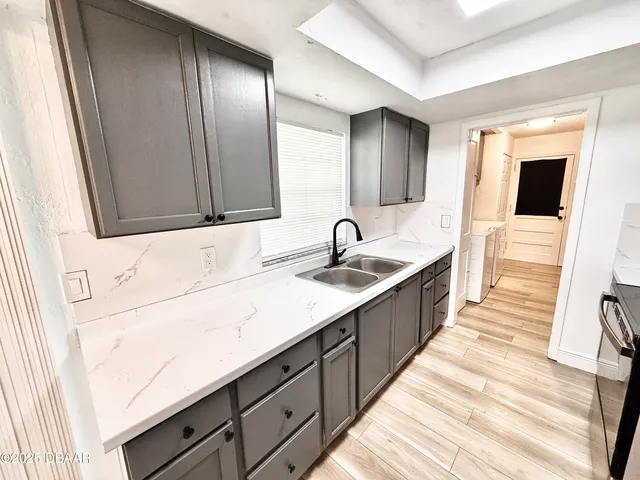 a large kitchen with a sink and large mirror