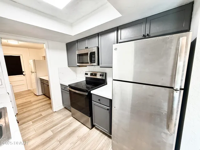 a white refrigerator freezer and a stove sitting inside of a kitchen