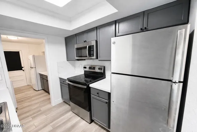 a white refrigerator freezer and a stove sitting inside of a kitchen
