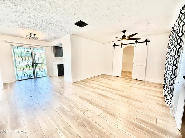 a view of a room with wooden floor and windows