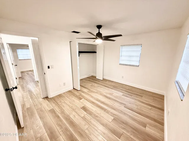 a view of a livingroom with wooden floor and ceiling fan