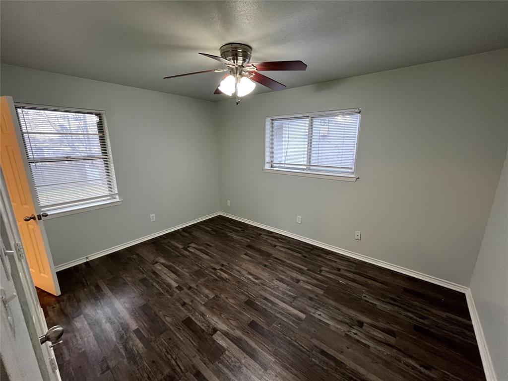 1841 South Perry Road Carrollton, TX 75006 - Photo 13 of 25 Unfurnished room with dark wood-style floors and ceiling fan