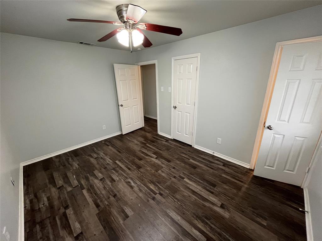 1841 South Perry Road Carrollton, TX 75006 - Photo 14 of 25 Unfurnished bedroom featuring dark wood-style floors and ceiling fan