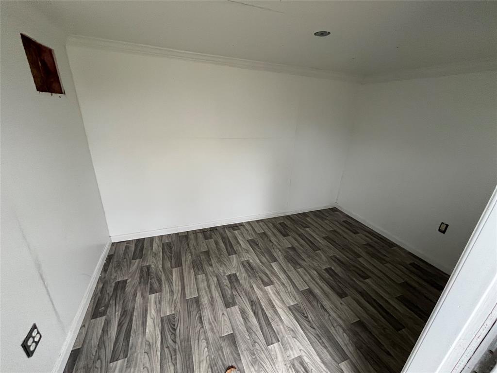 1841 South Perry Road Carrollton, TX 75006 - Photo 23 of 25 Empty room featuring wood finished floors and crown molding