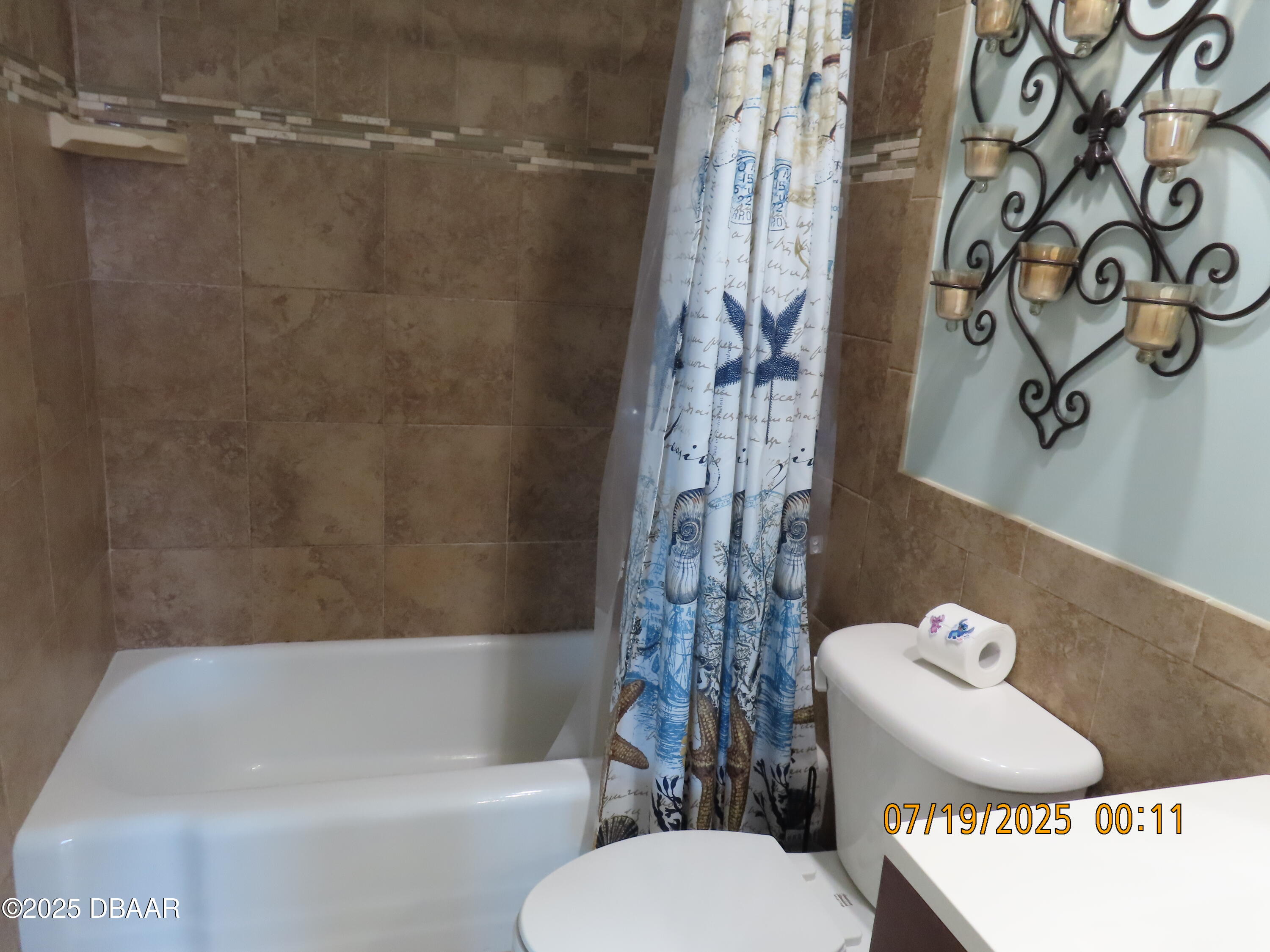2800 North Atlantic Avenue, Unit 1206 Daytona Beach, FL 32118 - Photo 15 of 27 a bathroom with a toilet and a shower curtain