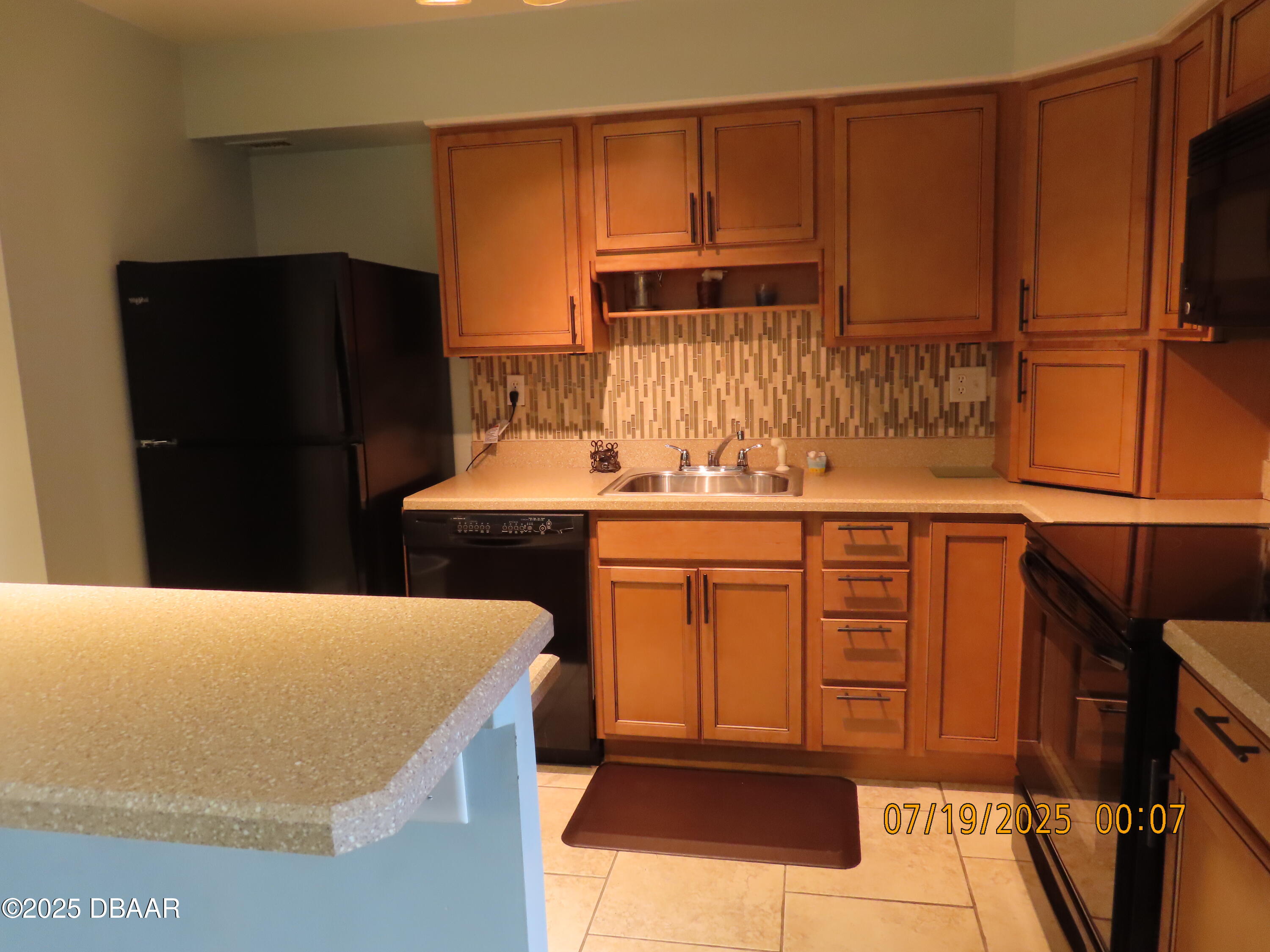 2800 North Atlantic Avenue, Unit 1206 Daytona Beach, FL 32118 - Photo 19 of 27 a kitchen with stainless steel appliances kitchen island granite countertop a refrigerator a stove and a sink