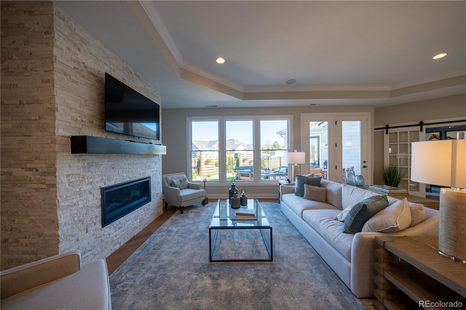 367 Josef Circle Fort Lupton, CO 80621 - Photo 19 of 36 a living room with furniture a fireplace and a flat screen tv