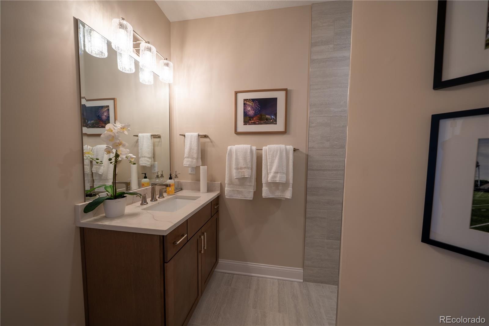 367 Josef Circle Fort Lupton, CO 80621 - Photo 9 of 36 a bathroom with a sink a mirror and a shower