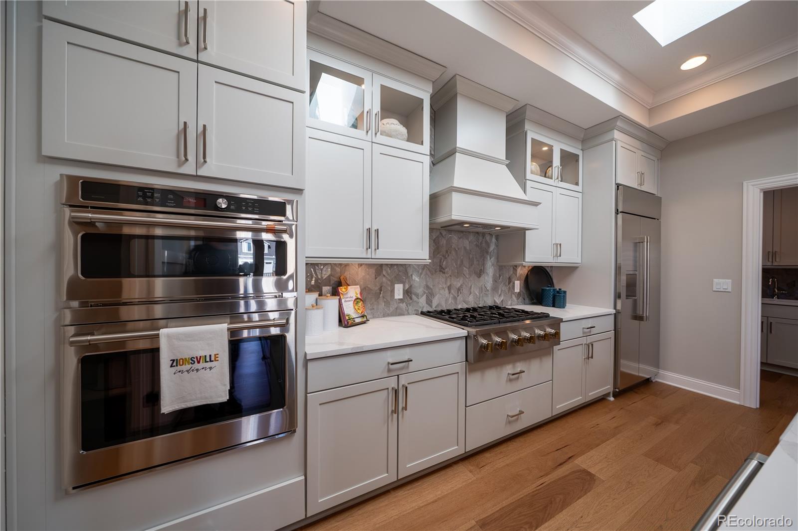 367 Josef Circle Fort Lupton, CO 80621 - Photo 10 of 36 a kitchen with stainless steel appliances granite countertop white cabinets and a stove top oven