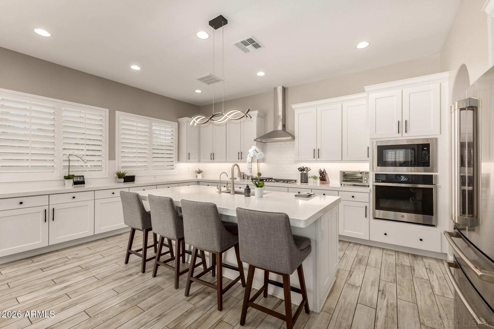 2285 East Athena Avenue Gilbert, AZ 85297 - Photo 9 of 58 a kitchen with stainless steel appliances kitchen island granite countertop a table chairs sink and cabinets