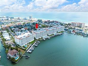an aerial view of a city with lots of residential buildings ocean and mountain view in back