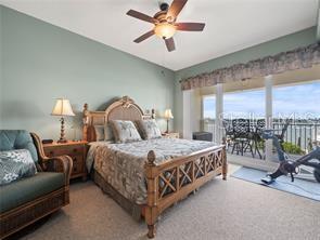 17735 Gulf Boulevard, Unit 204 Redington Shores, FL 33708 - Photo 14 of 23 a bedroom with a bed a chandelier and balcony
