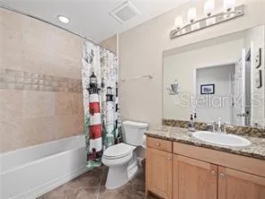 a bathroom with a granite countertop sink a toilet and shower