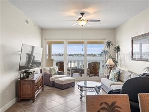 17735 Gulf Boulevard, Unit 204 Redington Shores, FL 33708 - Photo 7 of 23 a living room with furniture a flat screen tv and a large window