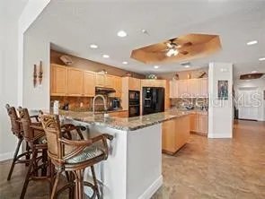 a kitchen with stainless steel appliances kitchen island granite countertop a table and chairs