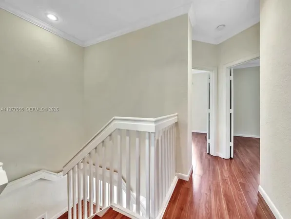 a view of a hallway with wooden floor and entryway