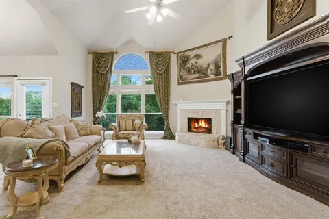 a living room with furniture a flat screen tv and a fireplace