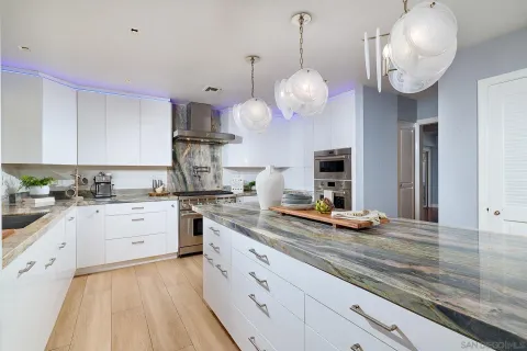 a kitchen with granite countertop stainless steel appliances a sink and cabinets